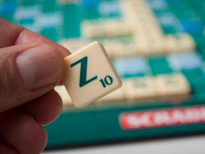 Une femme tient la lettre Z du jeu de scrabble