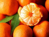 Une mandarine pelée et des mandarines entières