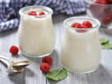 Deux pots de yaourt en verre avec des framboises