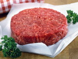 Un steak haché cru sur un papier