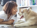 Une femme sourit à un jeune chien