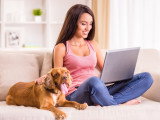 Une femme et son chien assis sur le canapé du salon