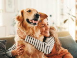 Une jeune femme serrant son chien dans ses bras