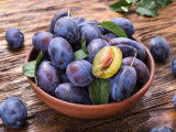 Un bol contenant des prunes violettes