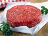 Un steak haché cru sur un papier