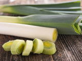 Des poireaux sur une table en bois