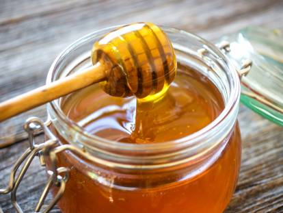 Un bocal de miel avec une cuillère
