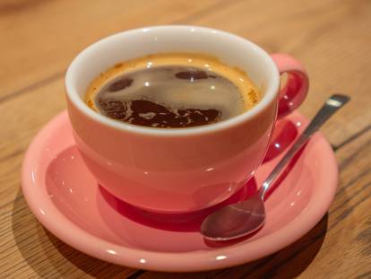 Une tasse de thé fumant sur une table avec une cuillère