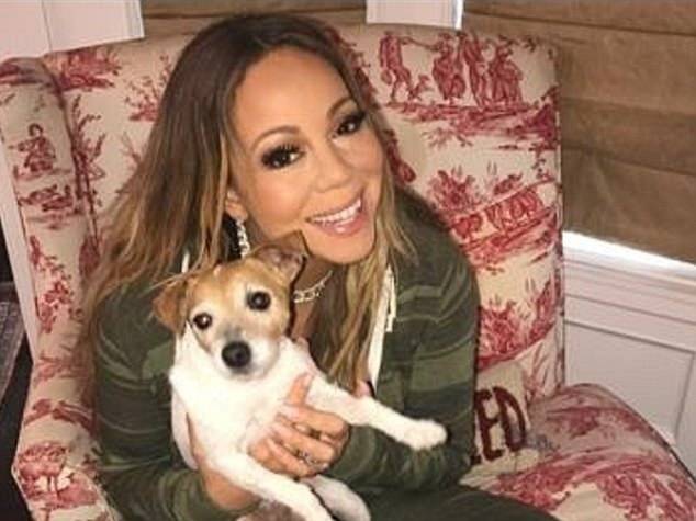 Mariah Carey assise sur un fauteuil et tenant dans les bras un de ses chiens