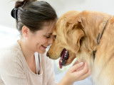 Une femme et son chien se font un gros câlin