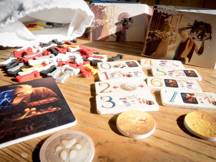 Les pièces du jeu « Doggy Bag » disposées sur une table en bois