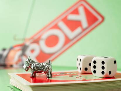 Le pion du chien su jeu Monopoly posé sur les cartes du jeu