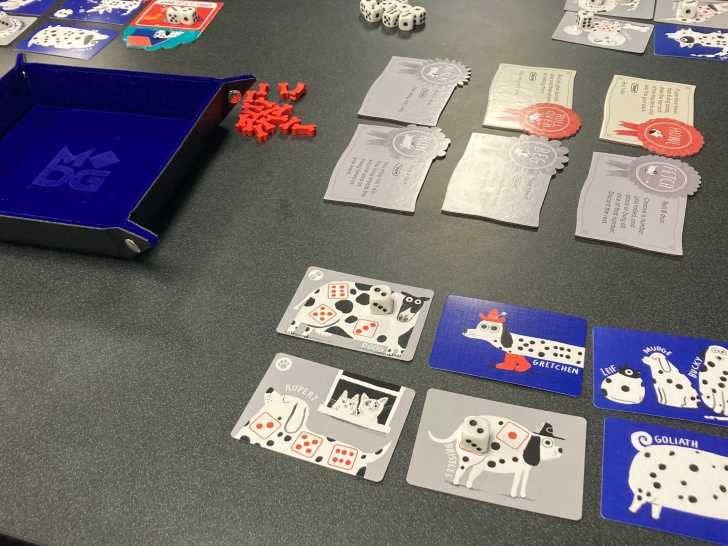 Des cartes et des pièces du jeu de société « Spots » posées sur une table