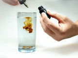 Une goutte d'argent colloïdal se dilue dans un verre d'eau