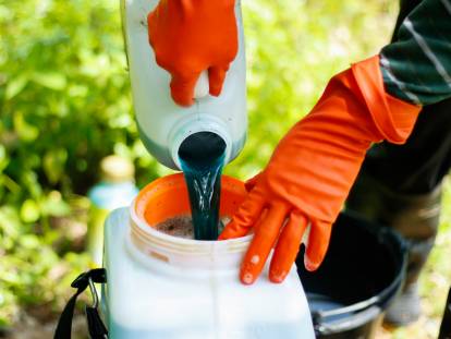 Un fermier mélange un pesticide dans un bidon