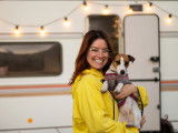 Une femme et son chien devant un camping-car