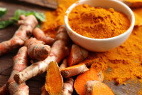 Du curcuma frais et en poudre dans un bol