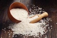 Un bol et une spatule contenant du riz sur une table en bois