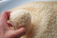 Une femme tient un doseur de riz