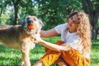 Un chien joue et se fait caresser par une fille à l'extérieur