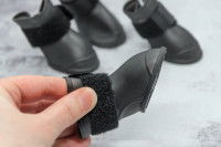 Une femme observe des chaussons de neige pour chien