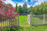 Un grand jardin avec une clôture et un portail en bois