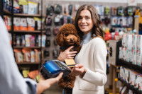 Une femme paye des accessoires pour chien dans une animalerie