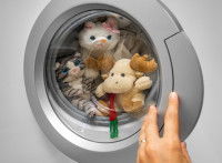 Une femme met des jouets et des peluches à la machine