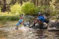 Un homme s'amuse avec ses deux chiens vêtus de manteaux rafraichissants Ruffwear