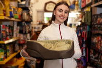 Une vendeuse tient un panier pour chien dans ses bras