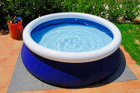 Une piscine gonflable installée dans un jardin