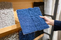 Une femme en train de choisir un tapis pour son chien