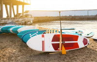 Des planches de paddle posées sur le sable