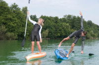Un jeune homme tombe de son paddle pendant que sa copine rigole