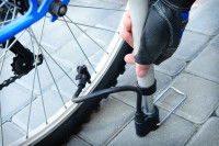 Une personne gonfle le pneu d'une trottinette