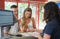 Une famille &agrave; la r&eacute;ception d'un camping consulte des documents