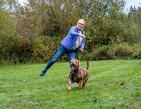 Une femme jouant à la balle avec son chien
