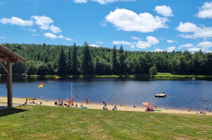 Une photo du lac Saint-Mathieu (Québec), avec du monde sur la plage et en train de se baigner