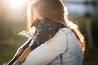 Une femme serrant un chien dans ses bras