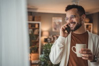 Un homme souriant au téléphone chez lui