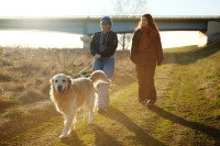 Deux femmes marchant sur un chemin avec un chien en laisse