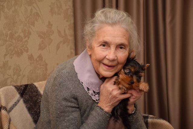 Une femme âgée tient son Yorkshire dans ses bras