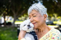 Une femme âgée faisant un câlin à son chien