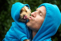 Un homme et un chien portant des tenues similaires et se faisant des bisous
