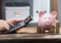 Un homme calcule son budget avec une calculatrice