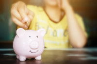 Une femme met des sous dans sa tirelire