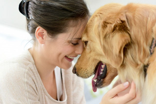 Une femme et son chien se font un câlin