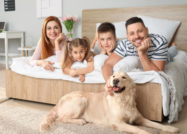 Deux parents, leurs enfants et un chien ensemble dans la chambre