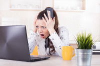 Jeune femme horrifiée devant son ordinateur