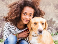 Une fillette avec son gros chien brun et blanc